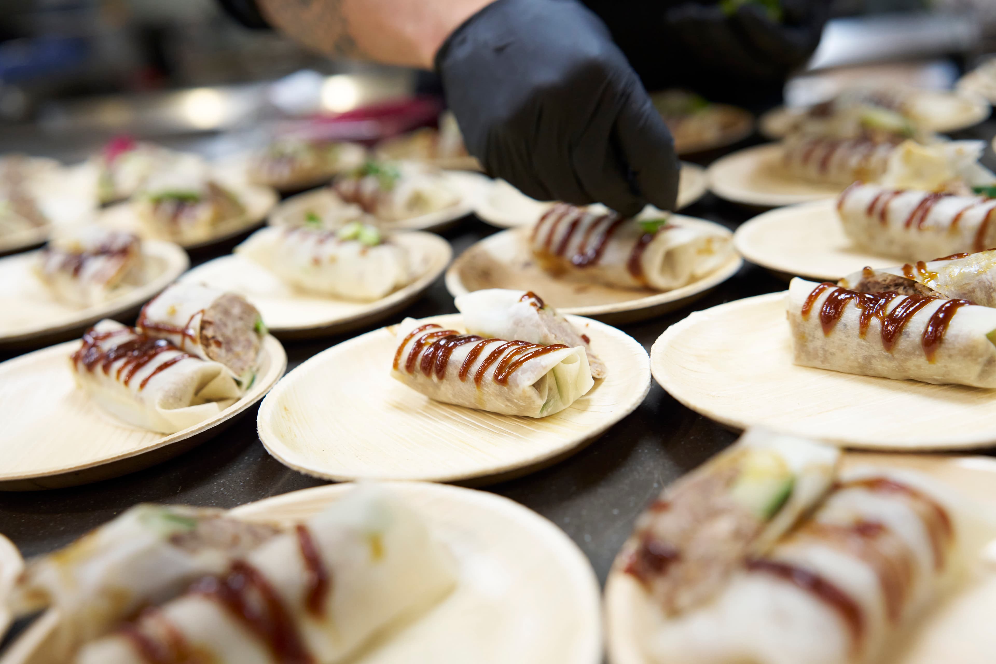 Rijen fijne walking-dinner-hapjes op bordjes, geplateerd door de chef